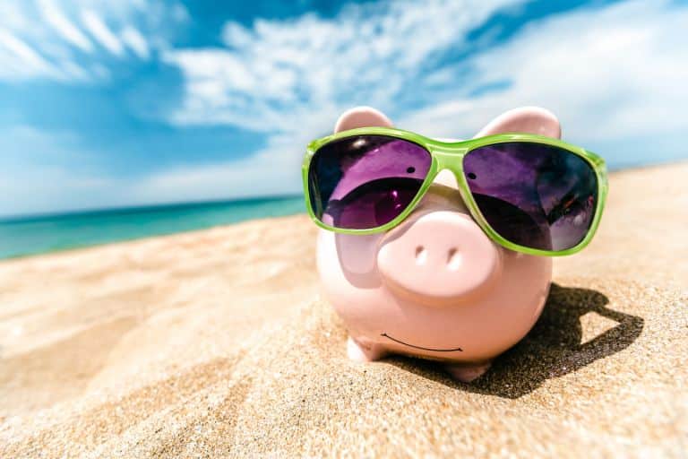 piggy bank with sunglasses on the beach