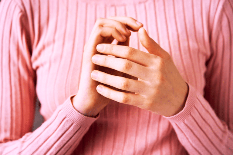 woman's hands EFT karate chop pose pink jumper
